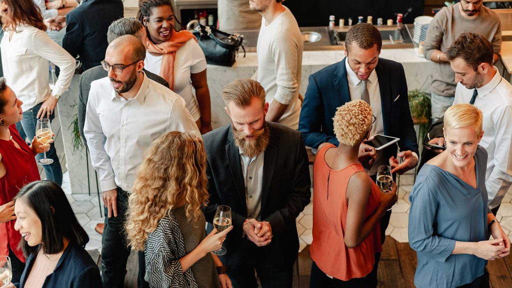 Group of professionals of all ages and backgrounds mingling at a networking event